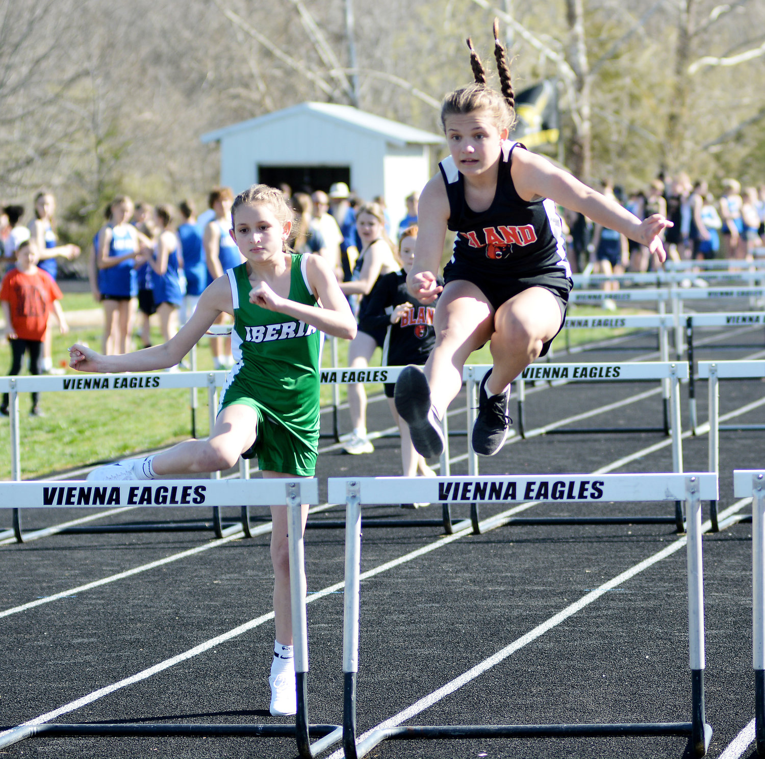 Natalie Lansford (far right) clears a hurdle for Bland’s Lady Bears during the 75-meter hurdles with Iberia’s Gabby Imperato not too far behind.